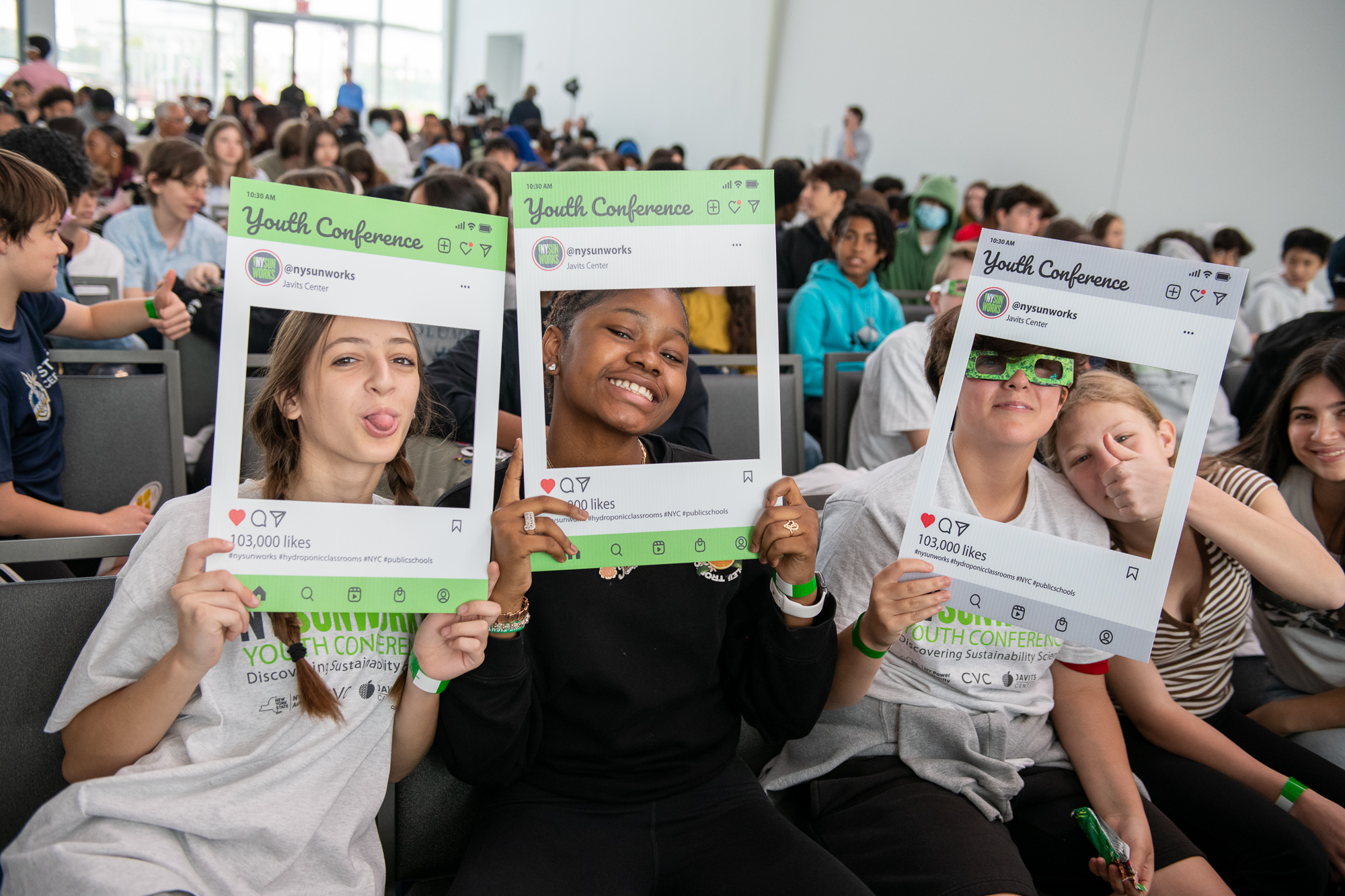 students smile and goof off with paper photo frames at the javits center