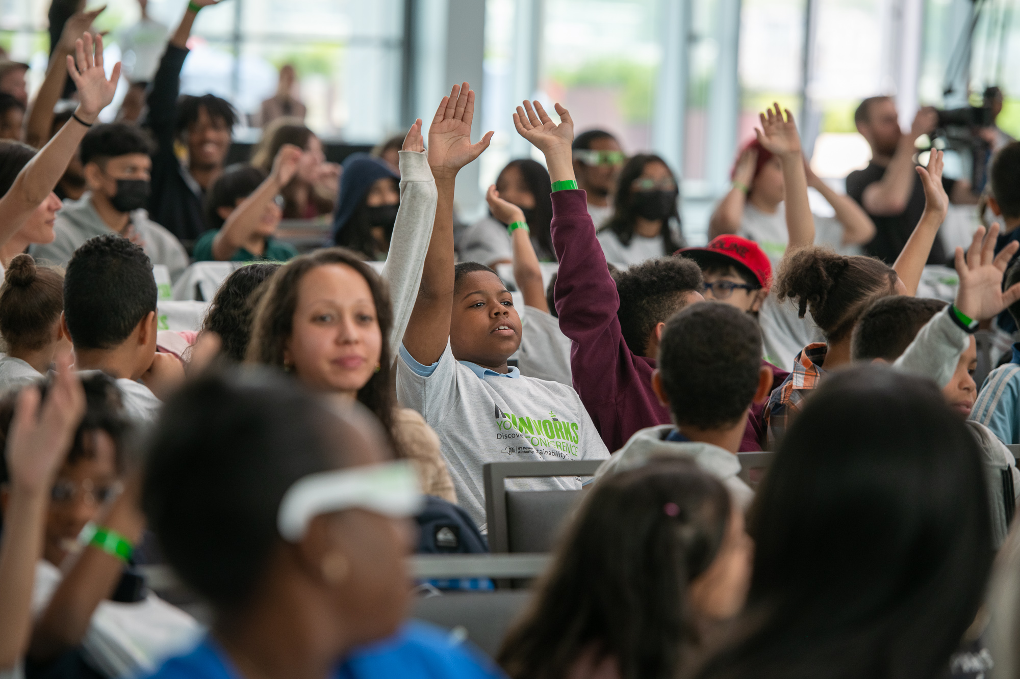 students in the audience raise their hands in support at the javits center
