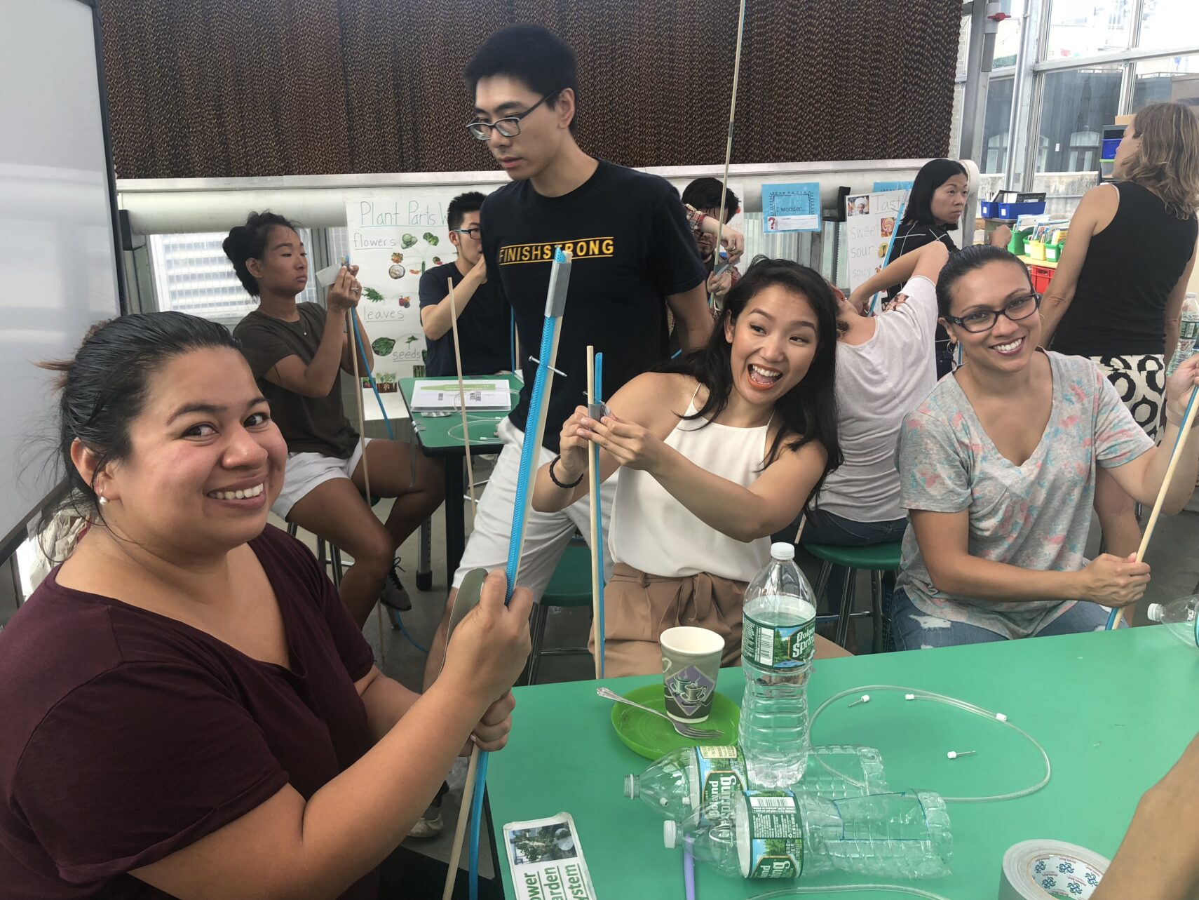 Image shows a group of teachers happily doing group activities within a classroom-based professional development session.