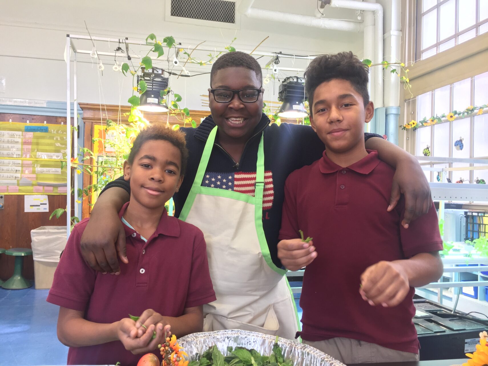 Unknown teacher poses next to two students in lab