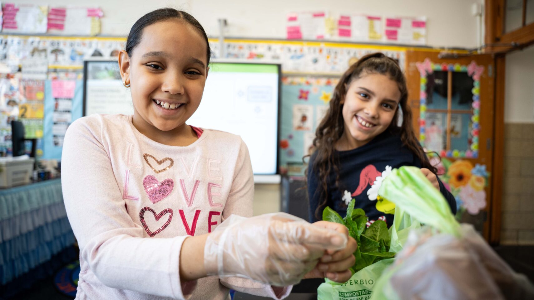 PS144Q - Two girls pack the harvest into plastic bags