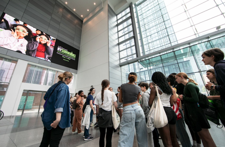 YC 2025 students stand in lobby of Javits Center
